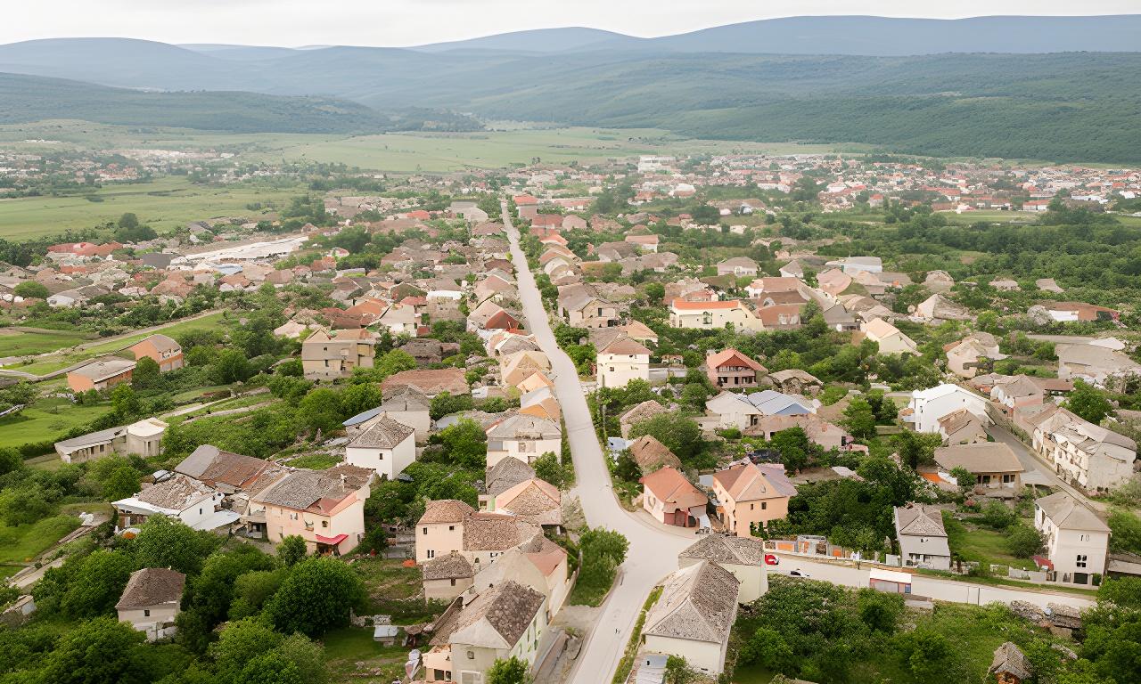 Panoramă a orașului Hațeg cu clădiri joase, străzi liniștite și dealuri la orizont
